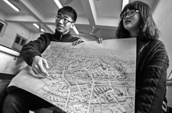 昨天上午，在禁忌书屋
，手绘图的作者郭龙(左)和何菡丹(右)在展示他们的创作手稿。 记者 姚卡/摄